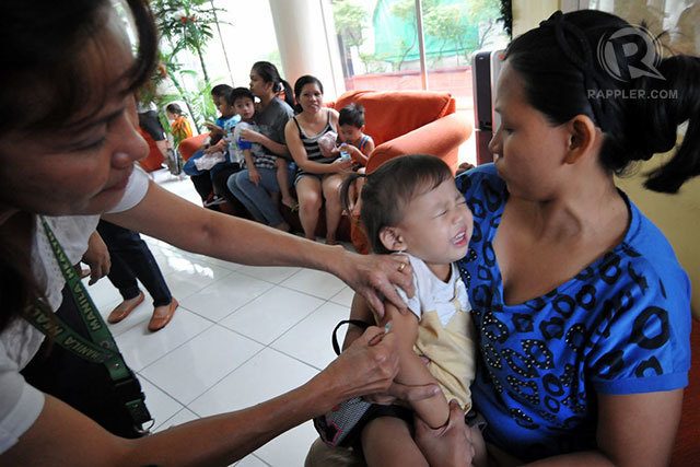 VACCINE'S IMPORTANCE. A health officer administers a measles shot on a young girl. File photo by Jose Del/Rappler  