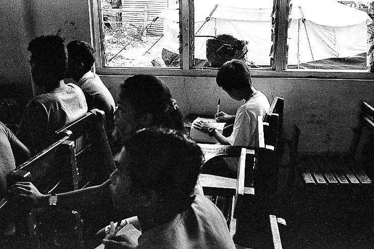 SCHOOL BLUES. Students attend classes in their typhoon-struck classroom after Haiyan in Tanauan, Leyte.  
