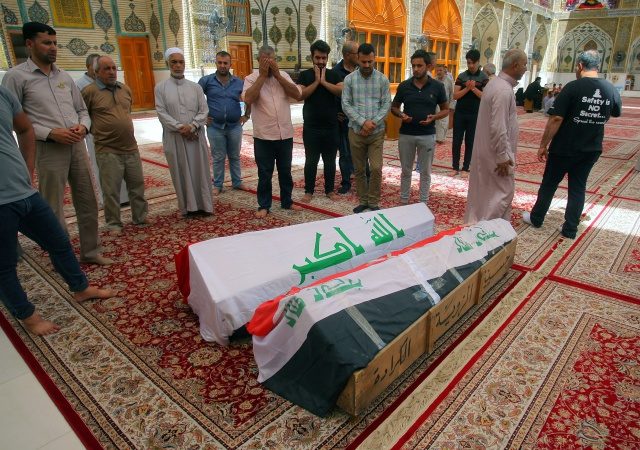 PEMAKAMAN KORBAN. Warga Irak berdoa di depan peti mati berisi jenazah korban pemboman yang dilakukan oleh ISIS pada Minggu, 3 Juli. Foto oleh Khider Abbas/EPA 