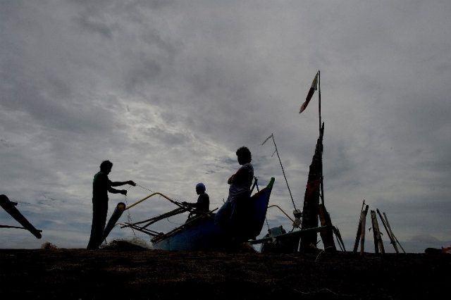 WORK NEEDED. Fishermen prepare their fishing net along a shore in Tacloban on the eastern island of Leyte on October 16, 2014. Tacloban was devastated by Super Typhoon Yolanda (Haiyan) on November 8, 2013. File photo by Noel Celis/AFP 