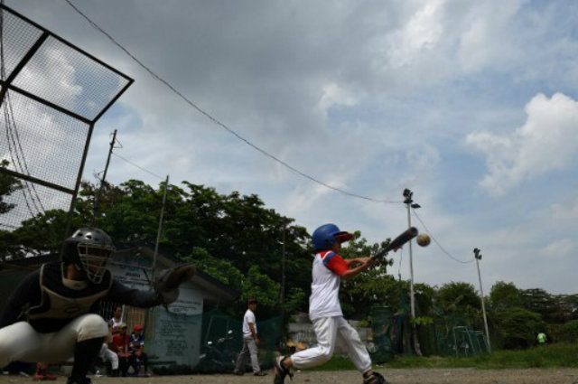 PRACTICE. Members of the Smokey Mountain baseball team during practice at the former dumpsite in Manila. TED ALJIBE / AFP 