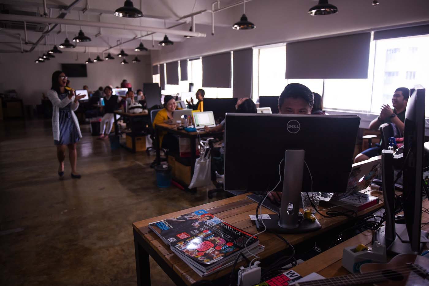The Canva team working at their desks, which are well lit by the natural sunlight from the windows. 