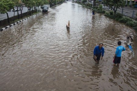 BANJIR. Warga berjalan melintasi banjir di Jalan Boulevard Barat Raya, Kelapa Gading, Jakarta, Selasa, 21 Februari. Foto Aprillio Akbar/ANTARA 