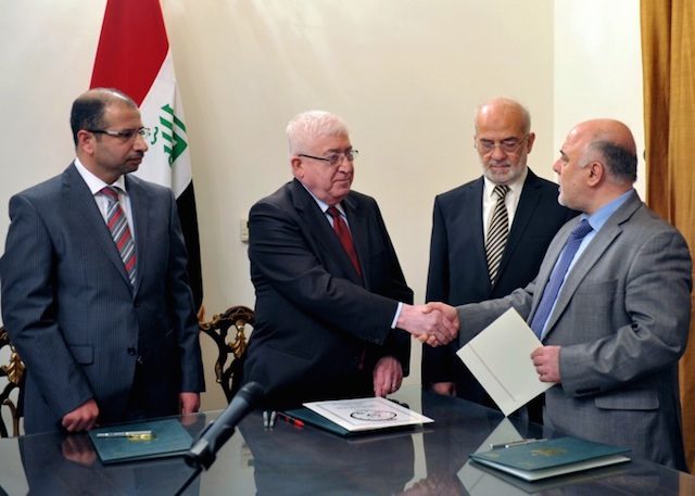 Newly elected Iraqi parliament speaker Salim al-Juburi (L) watching as Iraqi President Fuad Masum (2nd L) shakes hands with deputy parliamentary speaker Haidar al-Abadi (R) after he was tasked with forming a government during a brief ceremony broadcast on state television, August 11, 2014. Iraqi President's Office/Handout/AFP