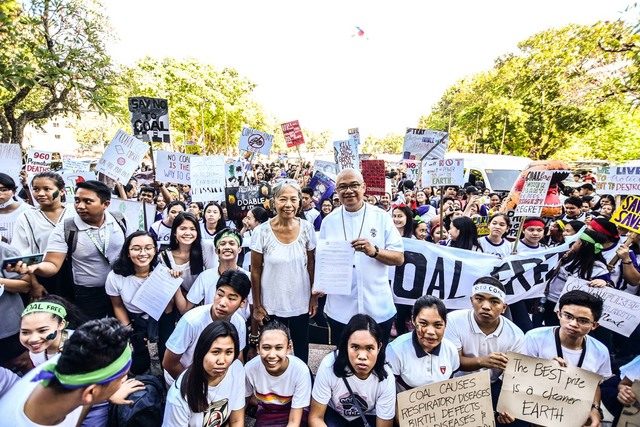 YOUTH PROTEST. San Carlos Bishop Gerardo Alminaza poses with youth protesters at the Negros Occidental Provincial Capitol on March 6, 2019, while holding the executive order declaring the province as coal-free. Photo by Rexor Amancio/Climate Reality Philippines 
