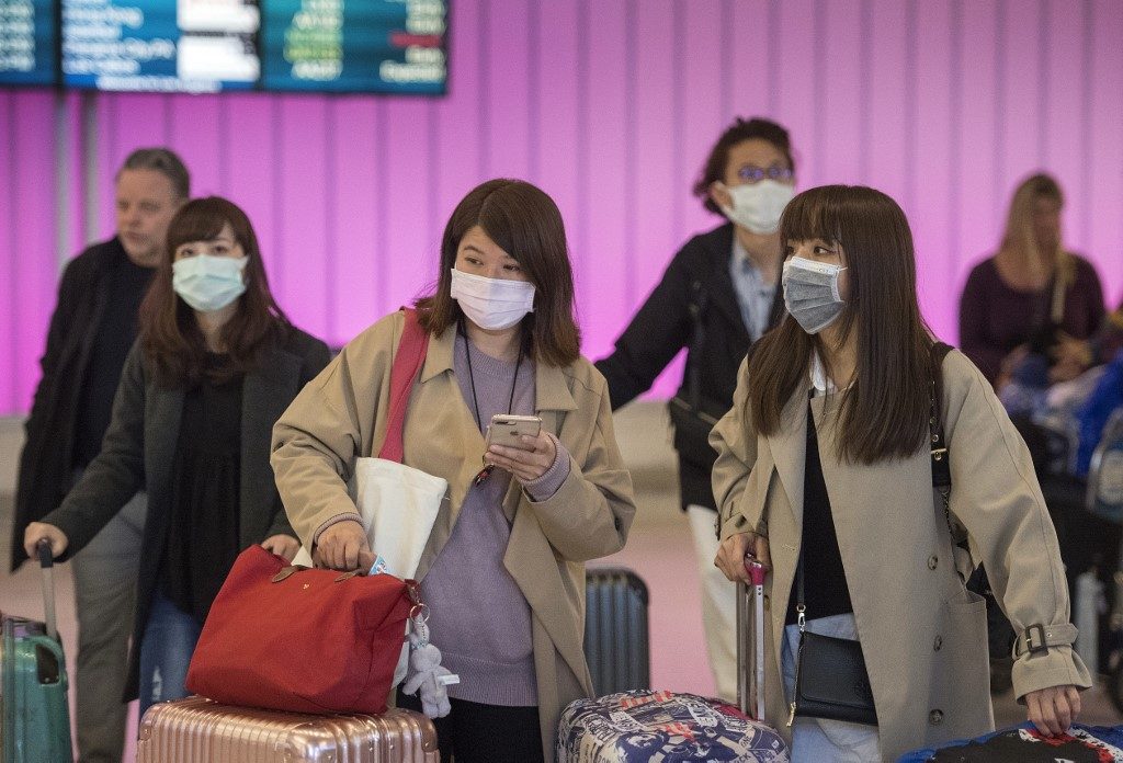 ESCAPE. In this file photo taken on January 22, 2020, passengers wear protective masks to protect against the spread of the Coronavirus as they arrive at the Los Angeles International Airport, California. Photo by Mark Ralston/AFP 