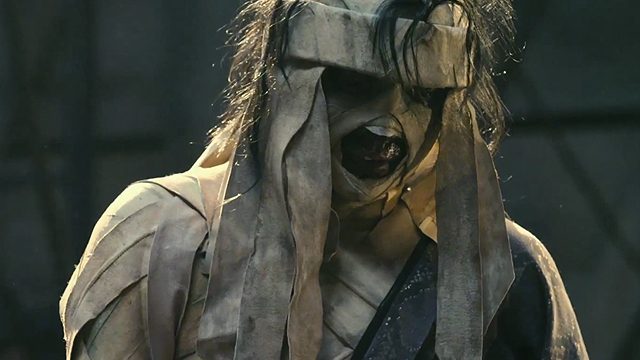 SHISHIO. The bandages contain not only his injuries, but also a malevolent and deeply damaged spirit. Screengrab from YouTube