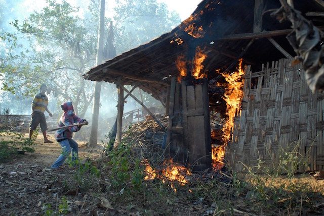 Dua orang laki-laki membakar dan merusak rumah milik keluarga Syiah di Sampang. Foto oleh AFP 