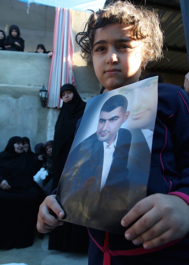 BERDUKA. Seorang anak gadis membawa foto ayahnya, Adel Tormos, yang menjadi korban ledakan di Beirut, Lebanon, 12 November 2015. Foto oleh STR/EPA 