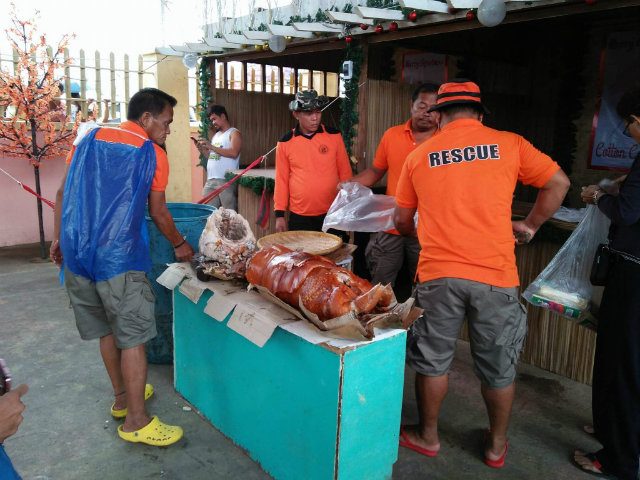 HOLIDAY CHEER. Matnog municipality responders prepare lechon for distribution to stranded passengers. Photo by Winston Regarde 
