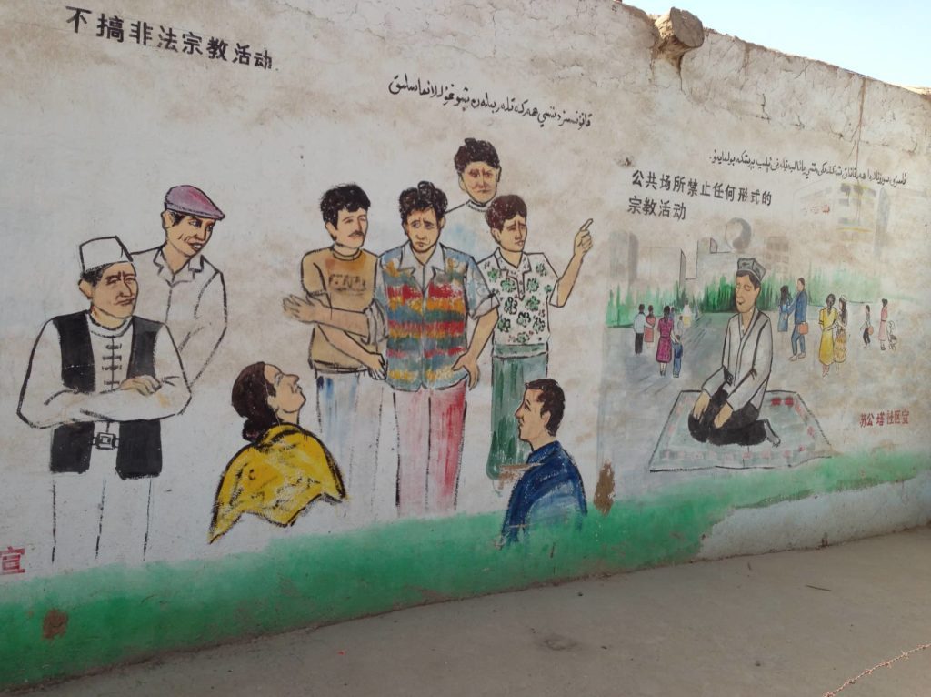 NO PUBLIC PRACTICE. Another wall mural in Xinjiang warns Uyghurs not to perform any religious practices in public spaces, and not to engage in illegal religious activity. Â© Coda Story 