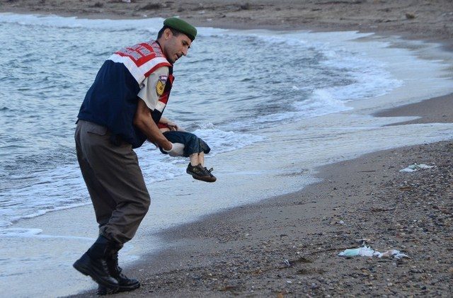 GONE TOO SOON. A Turkish police officer carries a migrant child's dead body off the shores in Bodrum, Turkey, on September 2, 2015 after a boat carrying refugees sank while en route to the Greek island of Kos. Photo by Dogan News Agency/AFP 