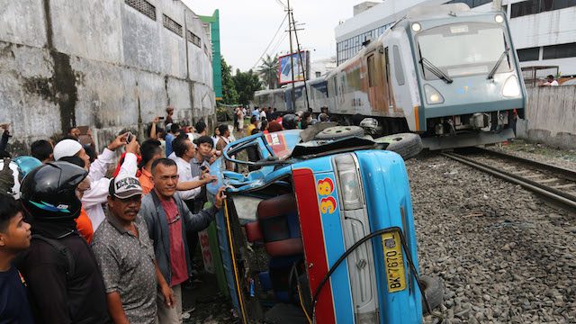 ILUSTRASI KECELAKAAN. Warga melihat kondisi mobil angkutan kota (angkot) yang rusak ditabrak kereta api, di perlintasan Jalan Sisingamangaraja, Medan, Sumatera Utara 25 September 2015. 