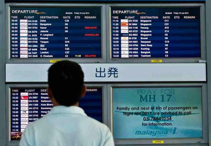 WAITING IN VAIN. A man looks at a flight information screen displaying a solidarity message for Malaysia Airlines flight MH17 at Kuala Lumpur International Airport in Sepang, Malaysia, on July 18, 2014. AFP photo/Manan Vatsyayana
