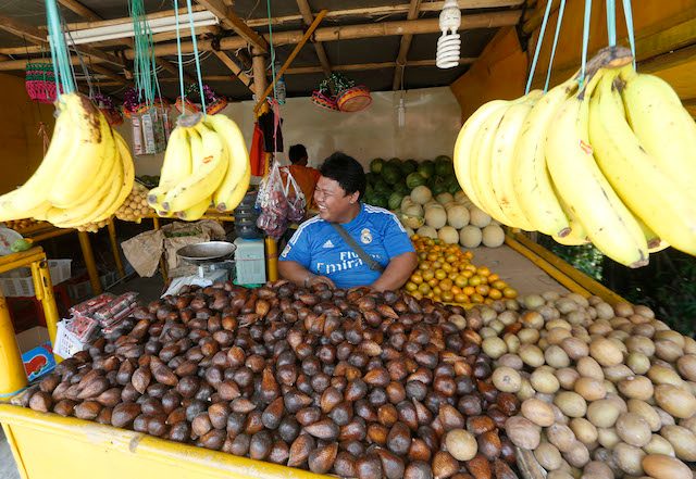 Seorang pedagang buah di pasar tradisional. Foto oleh Adi Weda/EPA 