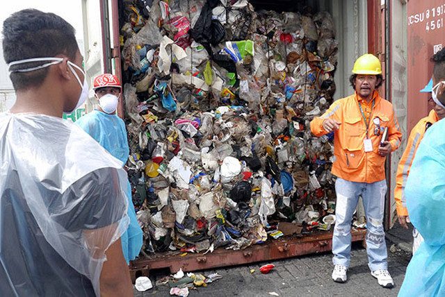 ILLEGAL GARBAGE. Geri Sañez of DENR-EMB opens one of the 103 container vans of trash shipped from Canada. Photo courtesy of BAN Toxics 