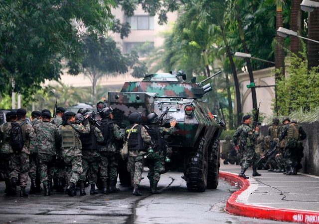 STANDOFF. Soldiers maneuver during an assault against rebel soldiers inside the Manila Peninsula Hotel. File photo by Dennis M. Sabangan/EPA