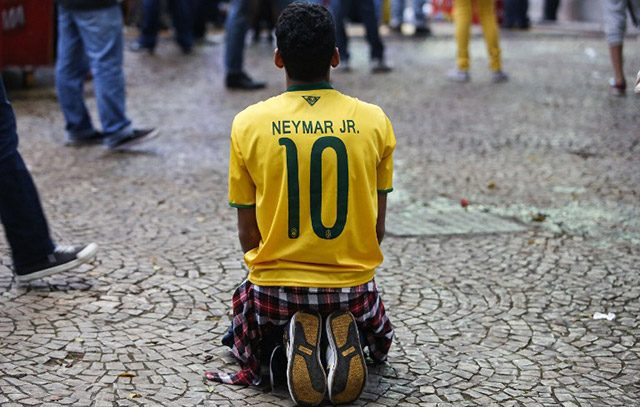 This Neymar fan who fell to his knees in dejection as he watched Germany demolish Brazil. Photo by Miguel Schincariol/AFP