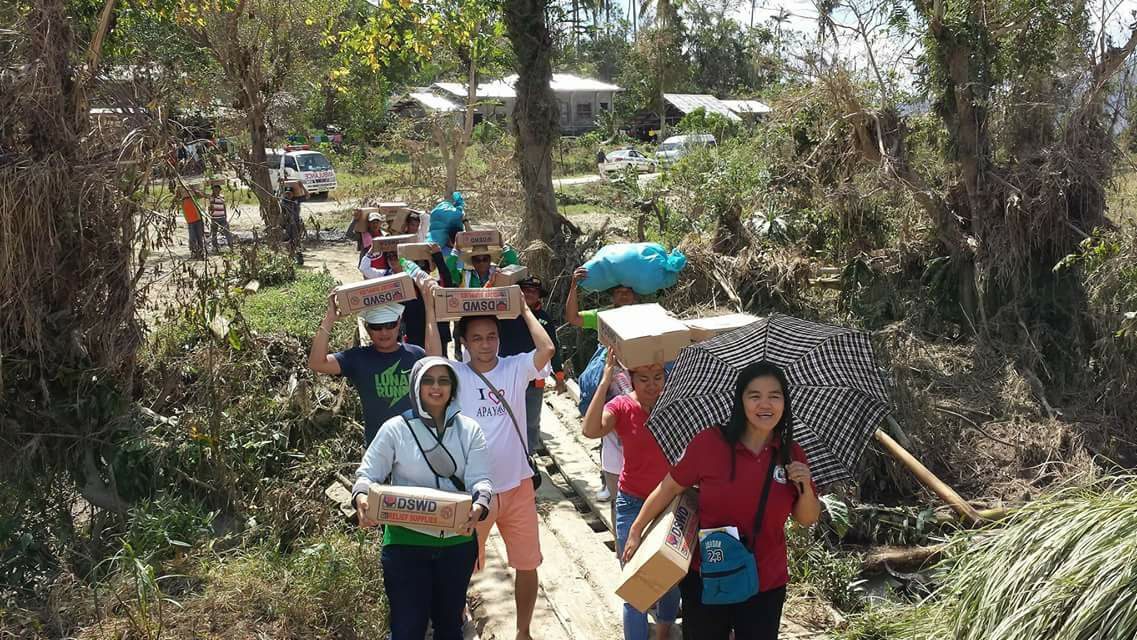 BY FOOT. DSWD social workers and volunteers bring boxes of relief supplies to a remote village in Apayao province in Cordillera by foot. 