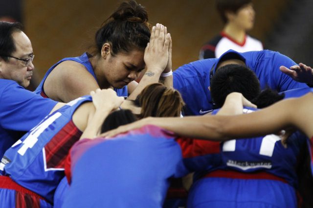 The team bows in prayer. Photo by FIBA.com 