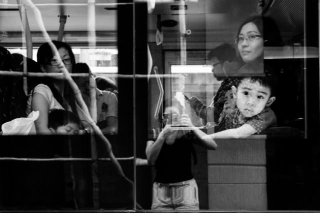 BUSY TRAIN. A woman and child commute home in Hong Kong.  