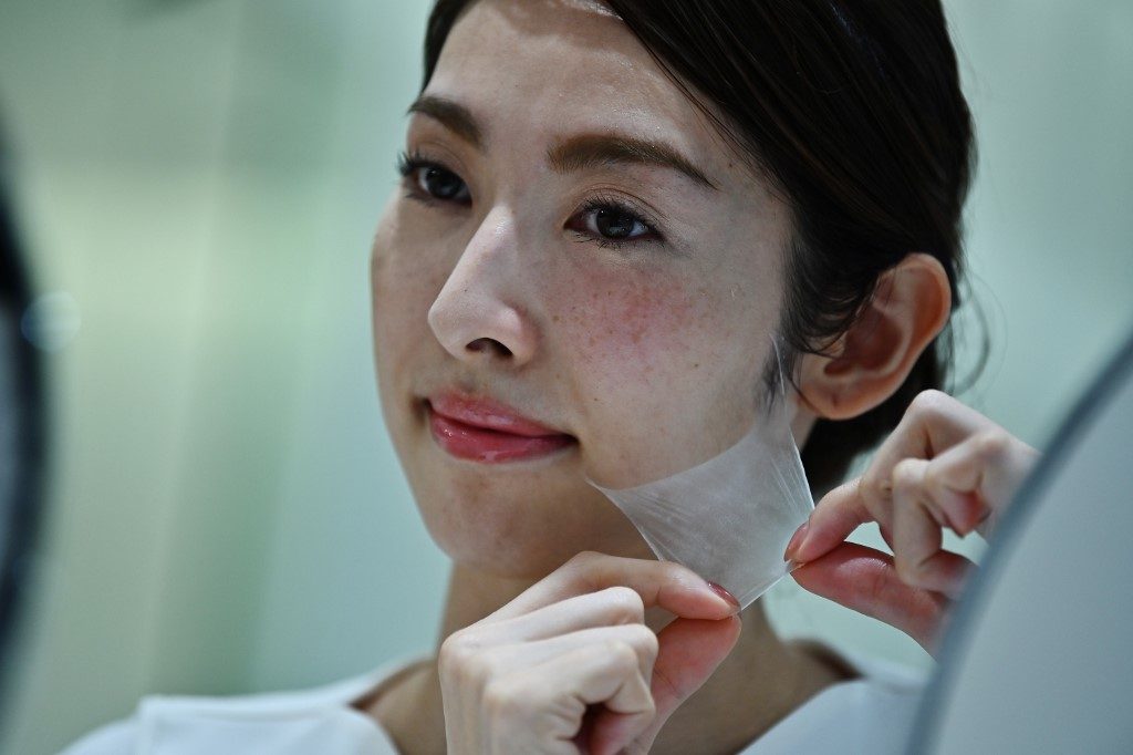 SO THIN. An employee for Japanese cosmetics company Kao removes a super thin transparent layer after using a palm-sized diffuser on her face, during a product demonstration in Tokyo. Photo by Charly Triballeau/AFP 