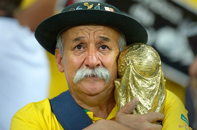 This fan who refuses to let go of his World Cup trophy replica. Photo by Thomas Eisenhuth/EPA