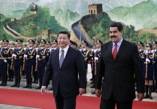 FADING? Venezuelan President Nicolas Maduro (R) and Chinese President Xi Jinping walk after reviewing an honor guard during a welcome ceremony at the Great Hall of the People in Beijing on January 7, 2015. File photo by Andy Wong/Pool/AFP    