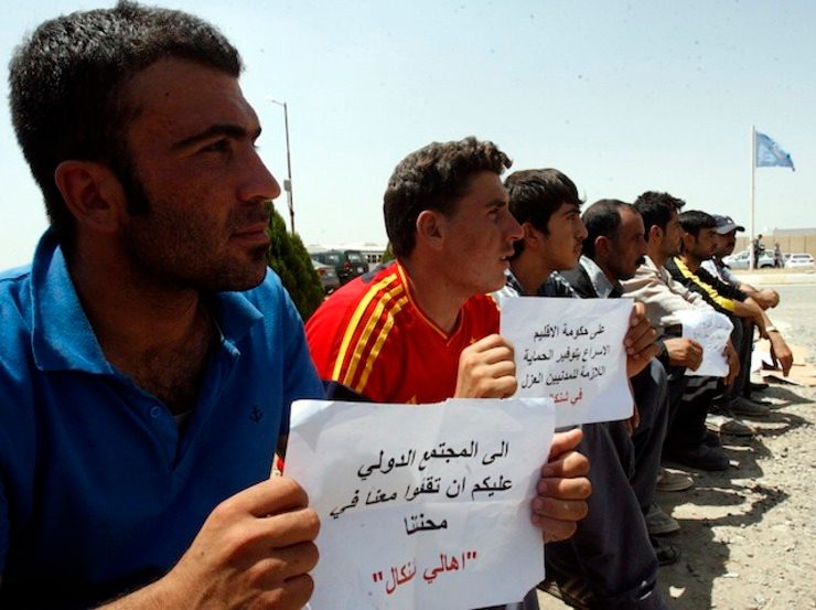 'HELP US' Yazidis displaced by fighting hold placards reading in Arabic 'The international community must help us during our ordeal' at a protest in front of the gates of the UN office in Arbil, northern Iraq, 04 August 2014. Mohammed Jalil/EPA