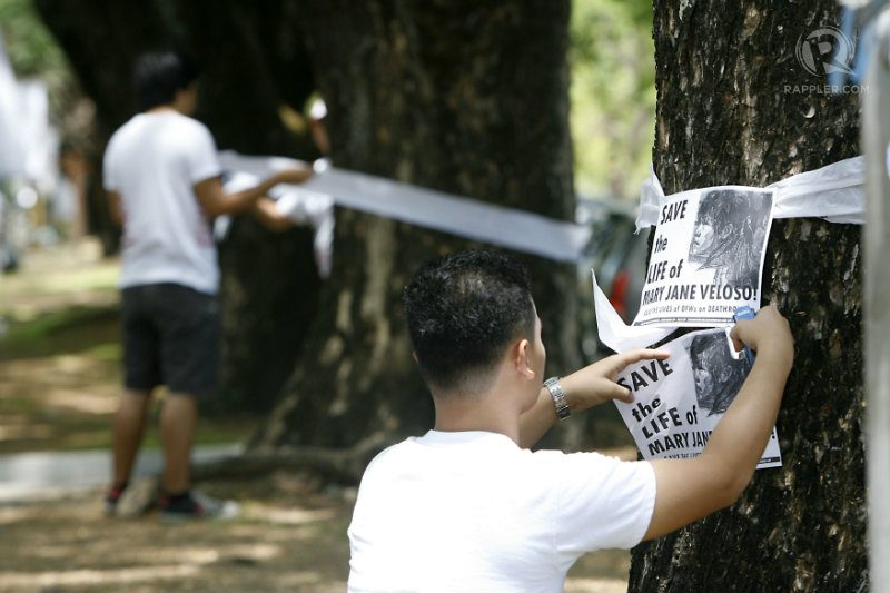 Students tie white ribbon on the trees in front of Palma Hall in the University of the Philippines in Quezon City on Monday, April 27, to call for the Indonesian government to spare the life of Filipina OFW Mary Jane Veloso who was convicted for drug trafficking and is sentenced to death. Photo by Ben Nabong/Rappler  