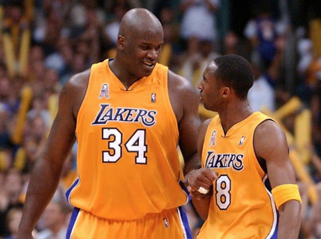 KOBE-SHAQ. Shaquille O'Neal smiles at teammate Kobe Bryant (R) Game 6 of the Western Conference Finals against the Sacramento Kings in May 2002. The Lakers defeated the Kings 106-102 to tie the best-of-7 series 3-3. File Photo by Lucy NICHOLSON/AFP 