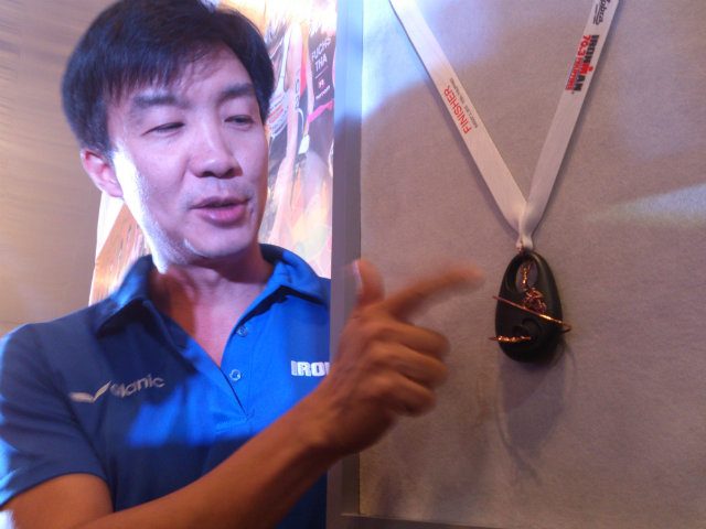 World-renowned designer Kenneth Cobonpue shows off the medal designed for this year's Ironman event. Photo by Rappler 