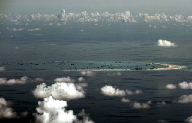RECLAMATION ACTIVITIES. An aerial photo taken though a glass window of a military plane shows the reclamation by China on Mischief Reef, part of the disputed Spratly Islands in the South China Sea, west of Palawan, Philippines, on May 11, 2015. File photo by Ritchie Tongo/Pool/EPA 