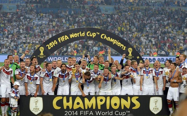 Germany's team pose for a photo with the World Cup trophy. Photo by Fabrice Coffrinin/AFP
