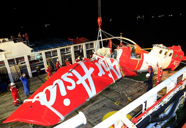 Indonesian national search and rescue agency (BASARNAS) crew lift up the wreckage of AirAsia QZ8501 aircraft tail from the Crest Onyx ship.  Photo by EPA