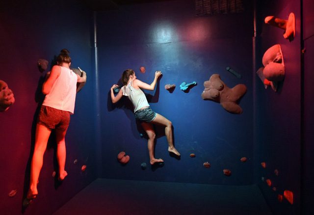 GETTING GRABBY. Demika Gilroy and Emily Richards from Australia play in the Bompas & Parr, Grope Mountain, a climbing wall where the foot-and hand-holds are sex organs and other bodily appendages. Photo by Timothy A. Clary/AFP