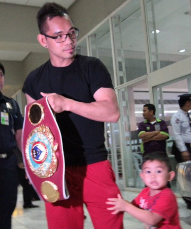 Nonito Donaire Jr shows off his new belt as his son quarrels for attention. Photo by Jedwin M Llobrera 