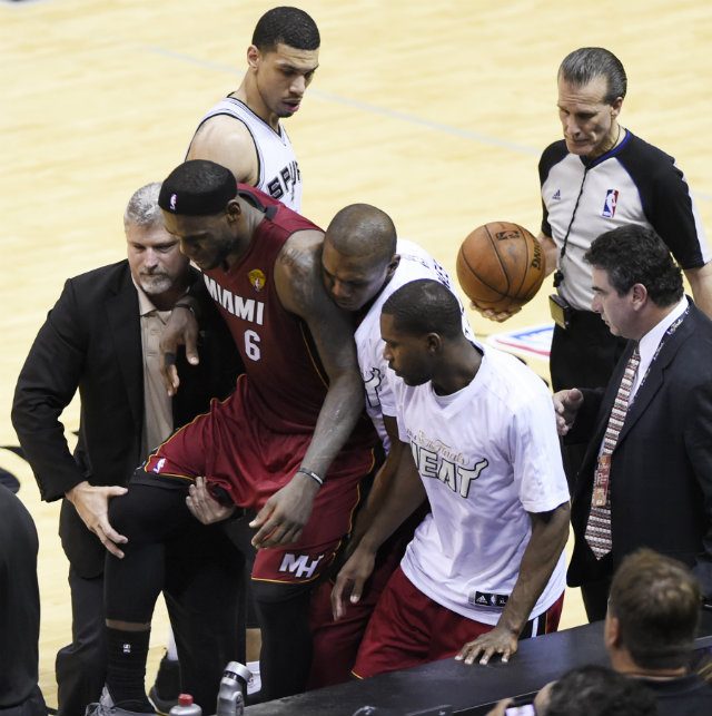 LeBron James is helped off the court after suffering severe cramps in the fourth quarter. Photo by John B. Mabanglo/EPA