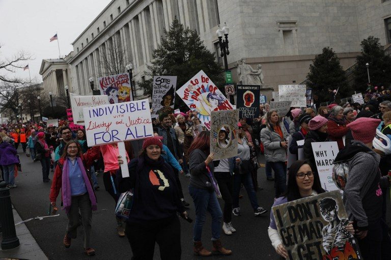 MAKING A STAND. Protesters march past the Rayburn House Office Building during the Women's March on Washington January 21, 2017 in Washington, DC. Aaron P. Bernstein/Getty Images/AFP 