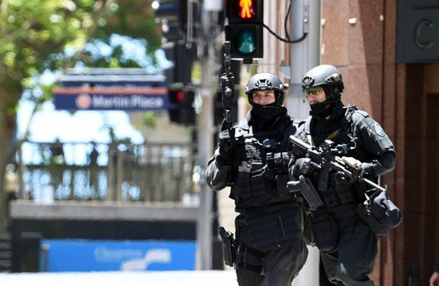 UNUSUAL SIGHT. Armed police are seen outside a cafe in the central business district of Sydney on December 15, 2014. Photo by Saeed Khan/AFP 