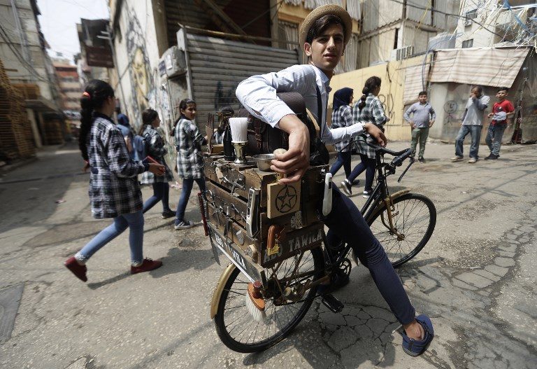 ALL IN BIKE. Everything he needs for a trim on the pavement is in a handmade trunk attached to the back of his pushbike: scissors, combs, electric razors and brushes. Photo by Joseph Eid 