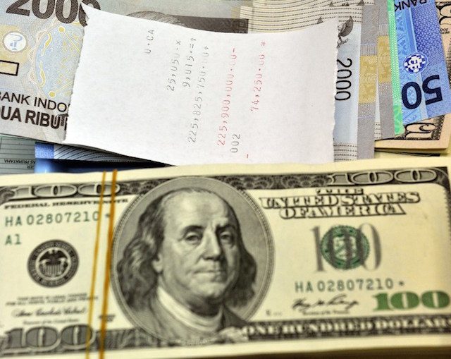 RUPIA DOLAR.  Dolar AS disandingkan dengan rupiah pada penukaran uang di Jakarta, September 2011. Foto oleh Bay Ismoyo/AFP 