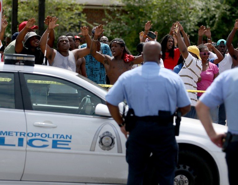ANOTHER INCIDENT. People raise their arms while chanting, 'Hands up, Don't Shoot', as they stand nearby to where St. Louis police say officers shot and killed a 23-year-old man who was wielding a knife and refused to drop it on August 19, 2014 in St Louis, Missouri. Joe Raedle/Getty Images/AFP