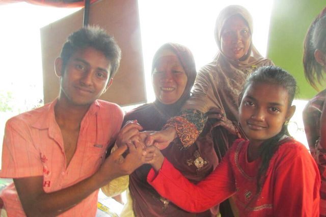 Suwarni dan anaknya, Dede, menganggap pengungsi Bangladesh, Muhammad Lalon, sebagai anggota keluarga sendiri. Foto oleh Rio Tuasikal/Asia Calling 