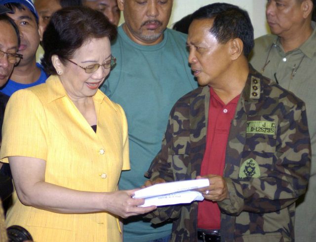OPPOSING GLORIA. Then Makati Mayor Jejomar Binay shows a copy of his suspension order to former president Corazon Aquino (L) on October 17, 2006. Then one of President Gloria Arroyo's most vocal opponents, Binay was suspended for 60 days over corruption allegations. He deemed the move as political harassment. File photo by Joel Nito/AFP  