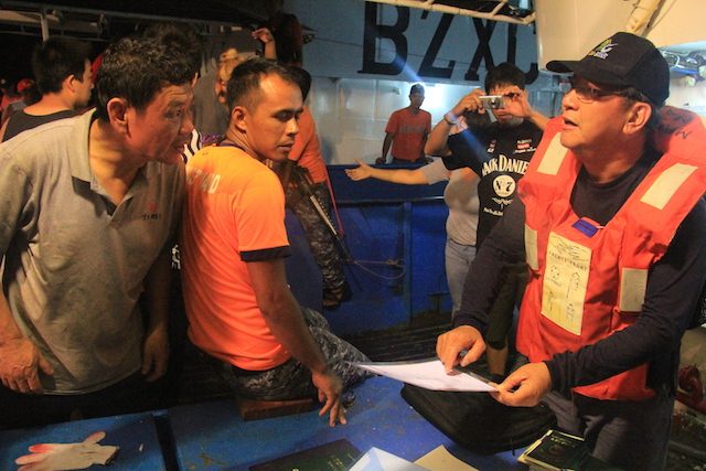 BFAR INSPECTION. A Philippine official inspects documents provided by the vessel's crewmembers. Photo courtesy of BFAR 