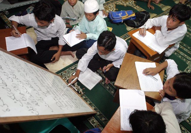Anak-anak laki-laki sedang belajar membaca Al Qur'an di Masjid Sunda Kelapa, Jakarta, pada 14 November 2003. Foto oleh Ardiles Rante/EPA  