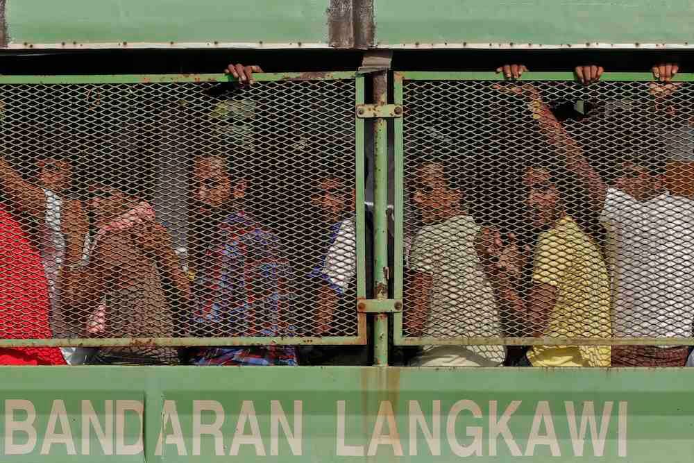 ‘THE WORLD WILL JUDGE.’ Bangladeshi and Rohingya migrants are seen in a truck as they arrive at a naval base before being transferred to Kuala Kedah jetty with the navy ship 'KD Mahawangsa', in Langkawi, Malaysia, 14 May 2015. Photo by Fazry Ismail / EPA 