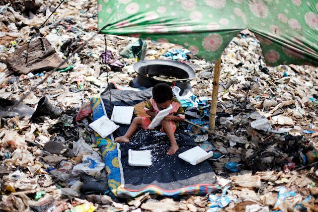 Seorang bocaH bermain di tempat pembuangan sampah, di Bantar Gebang, Bekasi, Jawa Barat, 30 aPRIL 2013. Foto oleh Mast Irham/EPA
 