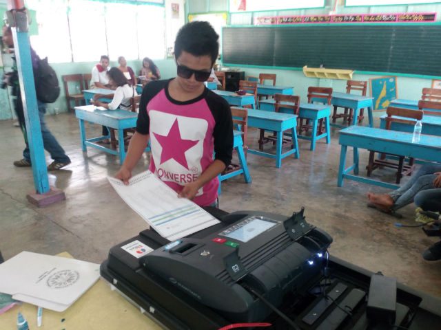 SPECIAL ELECTION. A voter in Cordova, Cebu, feeds his ballot through the vote counting machine. Photo by Moises Alarcon/Rappler 